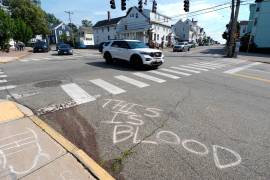 Se observa sangre en el pavimento cerca del lugar de un tiroteo en el que estuvo involucrado el Servicio de Inmigración y Control de Aduanas de Estados Unidos, el lunes 13 de julio de 2026 en Biddeford, Maine. La frase en el piso reza: Esto es sangre.