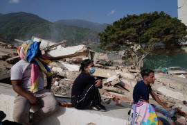 Residentes se sientan cerca de sus casas destruidas dos días después del sismo que azotó La Guaira, Venezuela, el viernes.