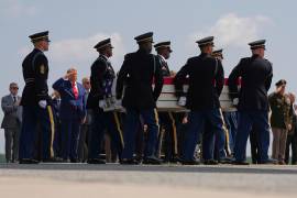El presidente Donald Trump saluda mientras una escolta militar carga los restos de la soldado Isabella Gonzales de Carrollton, Texas, en la Base de la Fuerza Aérea Dover en Delaware.