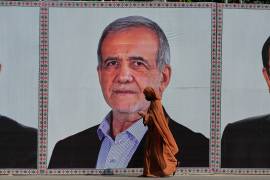Una mujer pasa frente a un anuncio con la imagen del presidente de Irán, Masoud Pezeshkian, en Islamabad, Pakistán.
