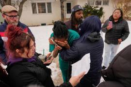 Una mujer (al centro) llora después de que agentes federales de inmigración arrestaran a un familiar, el domingo 11 de enero de 2026, en Minneapolis. (Foto AP/John Locher)