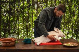 Rodrigo Barba acomoda el lechón en el asador, listo para iniciar uno de sus rituales culinarios.