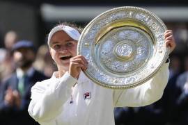 Barbora Krejcikova of the Czech Republic holds her trophy aloft after defeating Jasmine Paolini of Italy in the women's singles final at the Wimbledon tennis championships in London, Saturday, July 13, 2024. (AP Photo/Kirsty Wigglesworth)