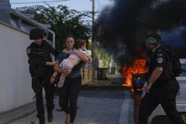 Agentes de policía evacuan a una mujer y a una niña de un lugar alcanzado por un proyectil disparado desde la Franja de Gaza, en Ashkelon, en el sur de Israel, el 7 de octubre de 2023.