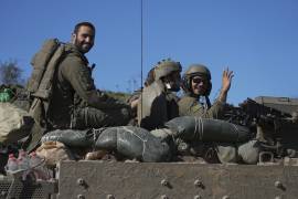 ARCHIVO - Soldados israelíes saludan a cámara desde un vehículo de transporte blindado mientras cruzan desde la Franja de Gaza a Israel el sábado 18 de enero de 2025. (AP Foto/Tsafrir Abayov, Archivo)