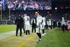 Joe Burrow, quarterback de los Bengals de Cincinnati, ve hacia el césped en la banca de su equipo durante la segunda mitad del partido de la NFL en contra de los Ravens de Baltimore.