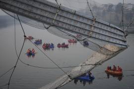 Rescatistas en botes buscan en el río Machchu junto a un puente colgante de cable que se derrumbó en la ciudad de Morbi, en el estado occidental de Gujarat, India.