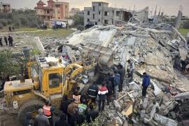 Voluntarios y rescatistas utilizan una topadora para retirar escombros de un edificio golpeado por un ataque aéreo israelí en Jan Yunis, en el sur de la Franja de Gaza, el jueves 20 de marzo de 2025. (AP Foto/Mariam Dagga)