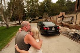 Allen Sather y su esposa Kimberley se abrazan ante la vivienda que arriendan en W. Indian Trail Road, que ardió en un incendio forestal en Spokane, Washington, el domingo 2 de agosto de 2026.