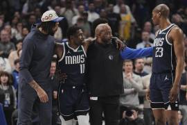 Kyrie Irving, de los Mavericks de Dallas, recibe ayuda tras sufrir una lesión en el partido contra los Kings de Sacramento.