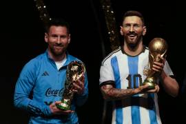 La estrella de Argentina Lionel Messi sostiene una réplica de la Copa del Mundo durante una ceremonia para reconocer a la selección argentina en las instalaciones de la CONMEBOL en Paraguay.