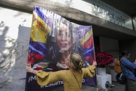 Una opositora al presidente de Venezuela, Nicolás Maduro, cuelga una imagen de la líder de la oposición, María Corina Machado, en el exterior de la embajada en la Ciudad de México, el 9 de enero de 2025, en la víspera de la toma de posesión de Maduro para un tercer mandato. FOTO: