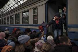 Gran cantidad de pasajeros se apresuran a abordar un tren que se dirige a Eslovaquia, el miércoles 2 de marzo de 2022, en Leópolis, Ucrania. AP/Felipe Dana