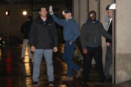 El presidente Joe Biden saluda mientras agentes del Servicio Secreto lo protegen a su salida de su sede de campaña en Wilmington, Delaware.