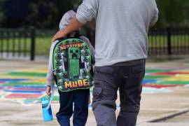 Un estudiante de la escuela primaria Funston lleva una mochila del modo supervivencia de Minecraft al llegar a la escuela en el barrio de Logan Square de Chicago.
