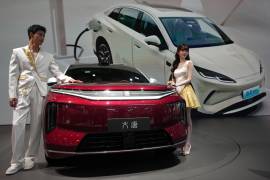 Dos modelos posan junto al último modelo de auto eléctrico de la automotriz china BYD en Auto China 2026, en Beijing, el 25 de abril de 2026.