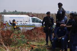 Investigadores forenses trabajan en el lugar donde se encontró el cuerpo de una mujer a las afueras de Johannesburgo, Sudáfric.