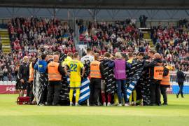 Jugadores de Dinamarca y Ucrania rodearon a Christian Eriksen mientras recibía atención médica sobre el campo.