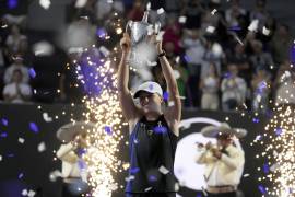 ARCHIVO - La polaca Iga Swiatek alza su trofeo de campeonas de las Finales de la WTA tras derrotar a Jessica Pegula en la final, el lunes 6 de noviembre de 2023, en Cancún, México.