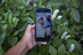 Mynor Cardona muestra una foto en su teléfono celular de su hija, Yenifer Yulisa Cardona Tomás, en el hospital mientras recibe una visita, en la Ciudad de Guatemala.