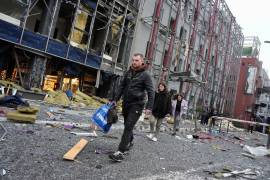 Las personas llevan sus pertenencias mientras abandonan su oficina tras un ataque aéreo ruso en Kiev, Ucrania, el lunes 19 de octubre de 2026.