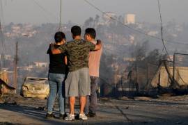 Residentes miran las casas quemadas y los escombros que dejó un incendio forestal que alcanzó a su vecindario en Viña del Mar, Chile, el sábado 3 de febrero de 2024.