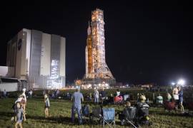 Invitados y empleados de la NASA observan el cohete del Sistema de Lanzamiento Espacial (SLS) de la NASA con la nave espacial Orion en el Centro Espacial Kennedy de la NASA.