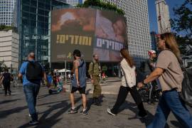 Varias personas pasan por delante de un cartel que pide la liberación de los rehenes retenidos por Hamás en Gaza desde hace casi un año, en Tel Aviv, Israel, el 10 de septiembre de 2024.