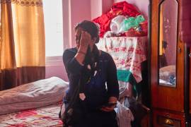 Una mujer de 54 años, madre de un migrante nepalí, comprueba su celular en Katmandú, Nepal, el martes 19 de mayo de 2026 sentada en la cama de su hijo antes de llamarle para saber is ha llegado a salvo a Abu Dabi. (