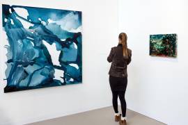 Una persona observa obras de arte en exposición durante Art Basel 2025 en el Grand Palais de París, Francia.