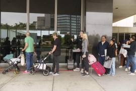 Marni Larsen y su hijo, Damon Rasmussen de Holladay, Utah, hacen fila con la esperanza de obtener el pasaporte de su hijo afuera de la Agencia de Pasaportes de Los Ángeles en el Edificio Federal en Los Ángeles.
