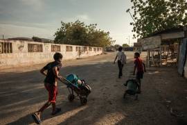 Ante el colapso del sistema de suministro, varios jóvenes transportan recipientes en carretillas por las calles de la ciudad costera.