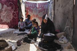 Nouf Al-Arja, de 30 años, que sufre desnutrición, cocina para su familia dentro de su tienda de campaña en un campamento para palestinos desplazados en Muwasi, Khan Younis, Gaza.