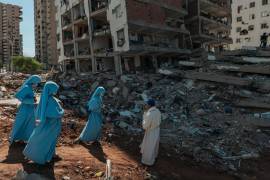 Un sacerdote y unas monjas bendecían los escombros de un edificio derrumbado en Catia La Mar, Venezuela.