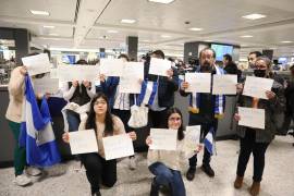 3/02/2023. Personas sosteniendo hojas con los nombres de los presos políticos nicaragüenses, expulsados de su país, mientras esperan su llegada en el aeropuerto de Dulles, Virginia.