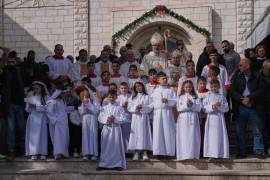 El cardenal Pierbattista Pizzaballa, patriarca latino de Jerusalén, con parroquianos palestinos tras dirigir una misa antes de las celebraciones navideñas en la iglesia católica de la Sagrada Familia en Ciudad de Gaza.