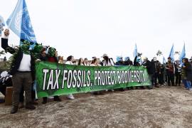 Manifestantes contra el cambio climático participan protestan con un cartel que dice “Impuestos a los fósiles, protección de la biodiversidad” durante la conferencia sobre biodiversidad COP16 en Roma.