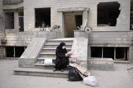 GRAF9203. TEHERÁN (IRÁN), 12/03/2026.- Una vecina revisa documentos frente a su casa del barrio de Resalat que sufrió un ataque de Estados Unidos e Israel el lunes. Ya había oscurecido y Marzieh se encontraba en pijama viendo la televisión cuando su casa comenzó a temblar y su vida, de repente, se convirtió en una película de terror: su barrio había sido alcanzado por tres misiles. EFE/Jaime León