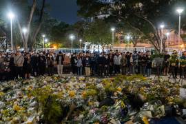 La gente ofrece flores a las víctimas cerca del lugar del incendio mortal del miércoles en Wang Fuk Court, una urbanización en el distrito de Tai Po, en los Nuevos Territorios de Hong Kong.