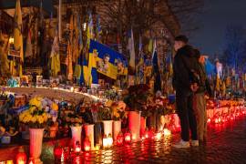 La gente enciende velas en la Plaza de la Independencia para conmemorar el cuarto aniversario de la invasión rusa de Ucrania, en Kiev, Ucrania