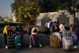 “Pasajeros varados por el cierre del Aeropuerto Internacional de Dubái esperan asistencia en el aparcamiento del aeropuerto de Dubái”, según la agencia de noticias AP.