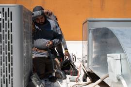 Brian Hermosillo se limpia el sudor después de instalar una nueva unidad de aire acondicionado en medio de una ola de calor sin precedentes.
