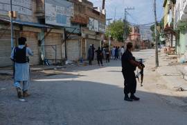En esta imagen, tomada con un smartphone, agentes de policía custodian una carretera cerca de donde se produjo una potente explosión en una mezquita en Kohat, Pakistán.