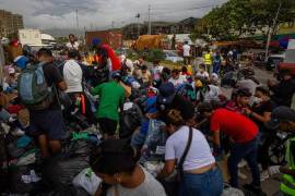 Personas buscan ropa en un campamento frente a edificios colapsados por los terremotos en La Guaira, Venezuela.