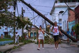 Peatones caminan en Santiago de Cuba después del paso del huracán Melissa.