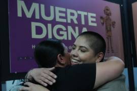 Samara Martínez, defensora de una ley para despenalizar la eutanasia, abraza a una amiga durante la exposición “Muerte Digna” en la estación de metro Ermita en la Ciudad de México.