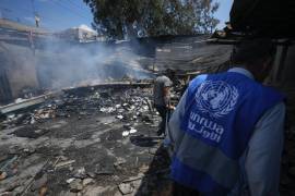 Los palestinos observan la destrucción tras un ataque israelí a una escuela administrada por la UNRWA, la agencia de la ONU que ayuda a los refugiados palestinos, en Nuseirat, Franja de Gaza.