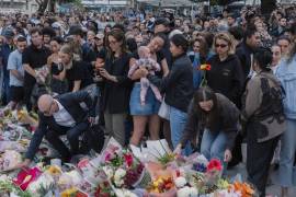 Personas depositan flores en un monumento improvisado en memoria de los fallecidos en el tiroteo mortal en Bondi Beach en Sídney, Australia.