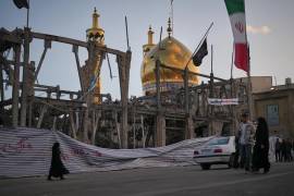 Peatones caminan junto a un edificio destruido en el complejo Grand Hosseiniyeh, con la mezquita visible al fondo, que alcanzada por ataques aéreos estadounidenses-israelíes en Zanjan, Irán, el 4 de abril de 2026.