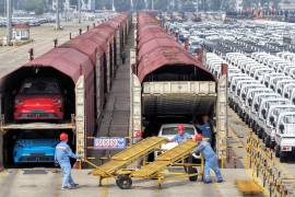 Trabajadores preparan autos para su envío en tren Yantai, en la provincia oriental china de Sandong, el 20 de junio de 2026.